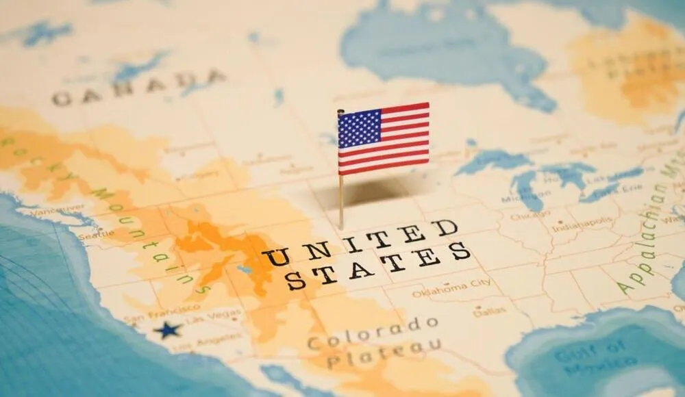 Map of the United States with a small American flag pin marking the central region.